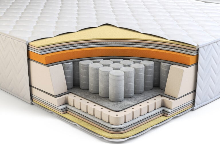 Close-up of mattress assembly layers, including foam, fabric, and spring components, neatly stacked and aligned. Each layer contributes to the overall comfort, support, and durability of the mattress