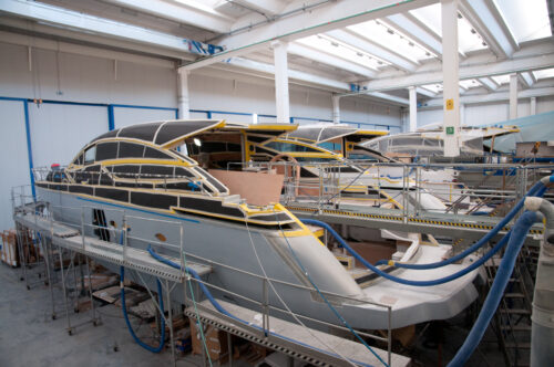 Applying high-performance marine adhesive to a boat’s hull in a production facility, ensuring strong, waterproof, and durable bonding for marine applications.