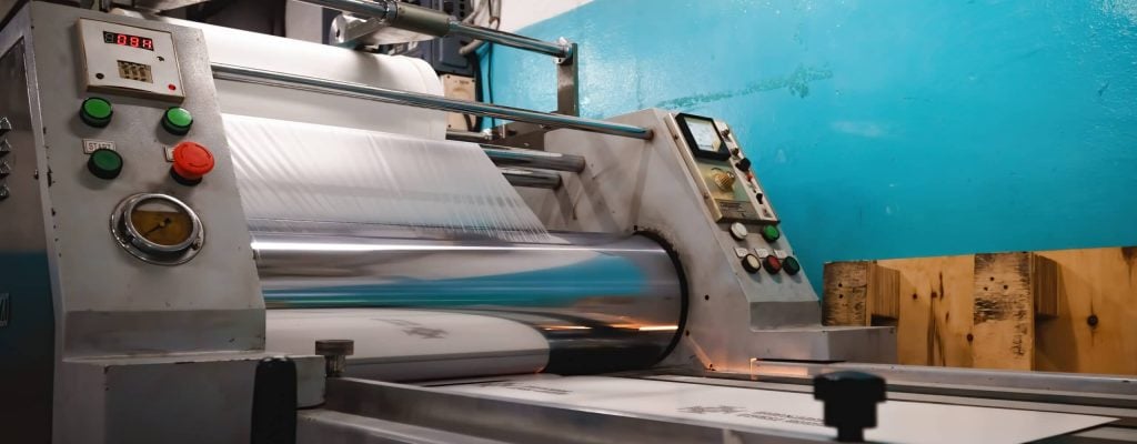 Industrial laminator, lamination of paper products. The manufacture of packaging. Water-based adhesive Industrial laminator, lamination of paper products. The manufacture of packaging. Outdated equipment. Company. Place for text.