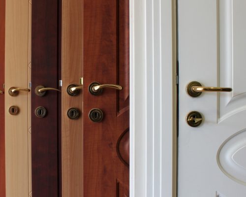 A close-up of a door manufacturing process showcasing adhesives bonding wood veneers, MDF cores, fire-rated materials, and metal components for enhanced durability and structural integrity